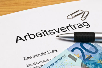 Bild eines Arbeitsvertrages, 20-Euro-Schein, Kugelschreiber sowie zwei Büroklammern